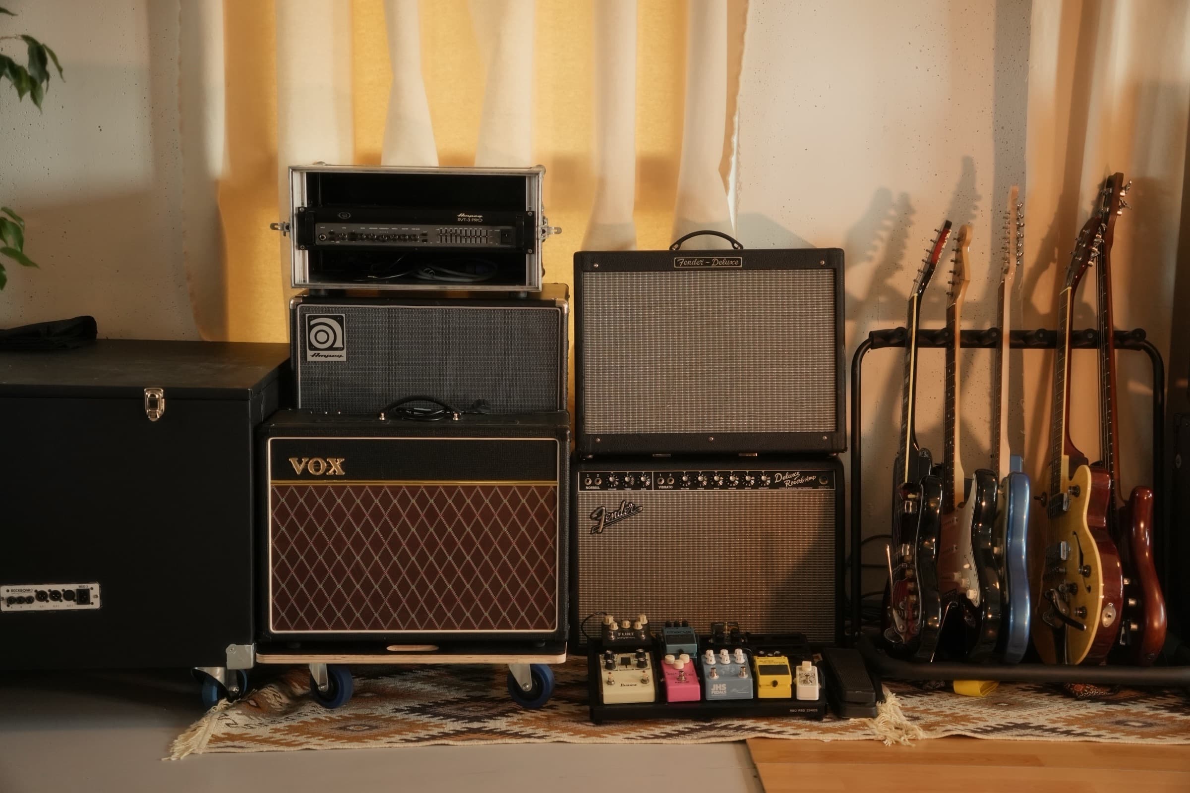 Guitars racked in front of the amp wall