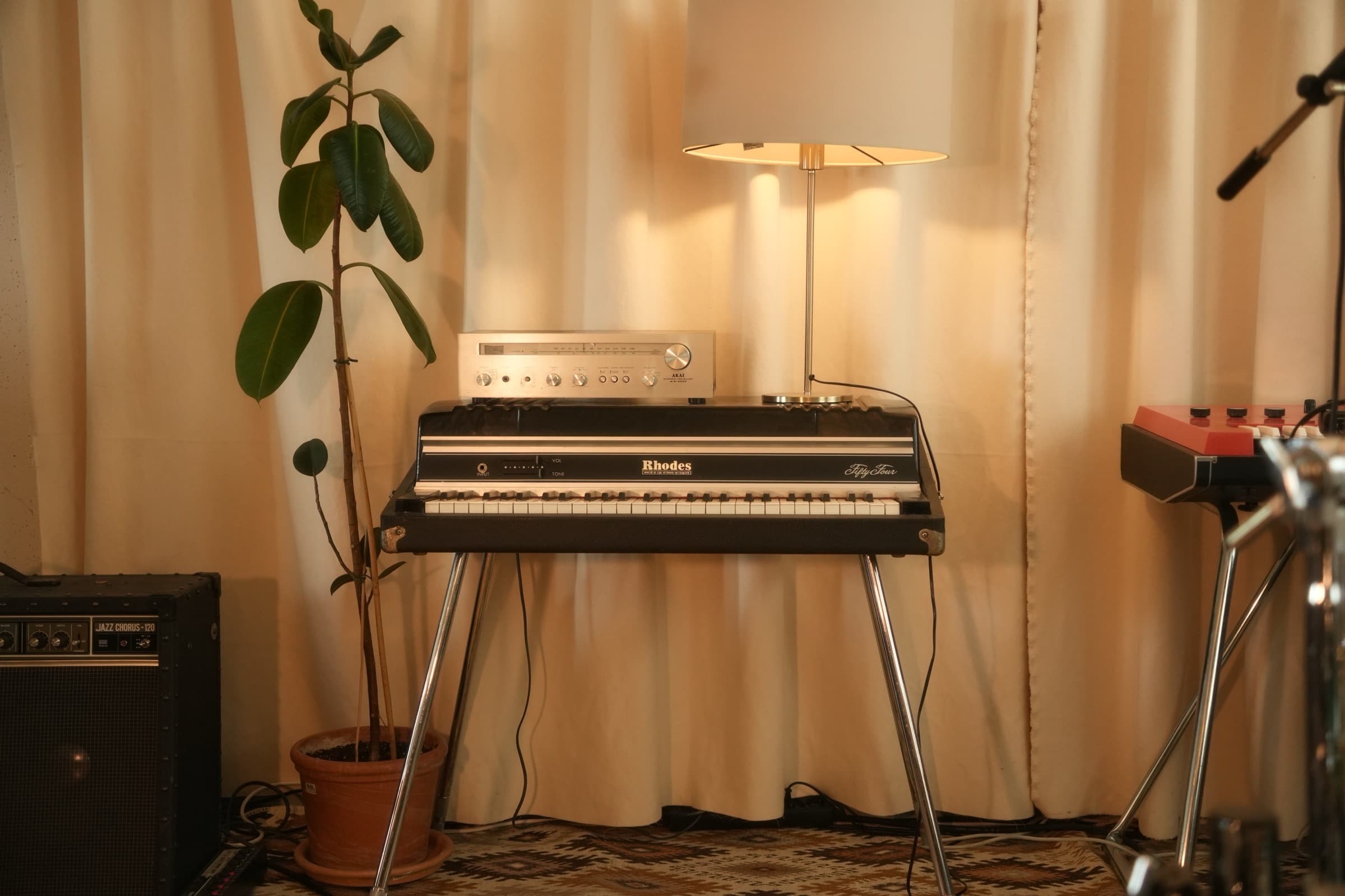 A Rhodes Fifty Four beside the window, lamp lit